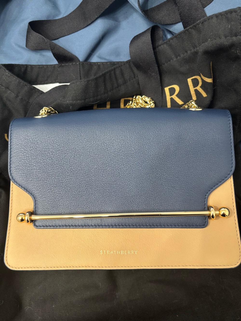 Strathberry blue, cream, and tan crossbody bag with gold hardware
